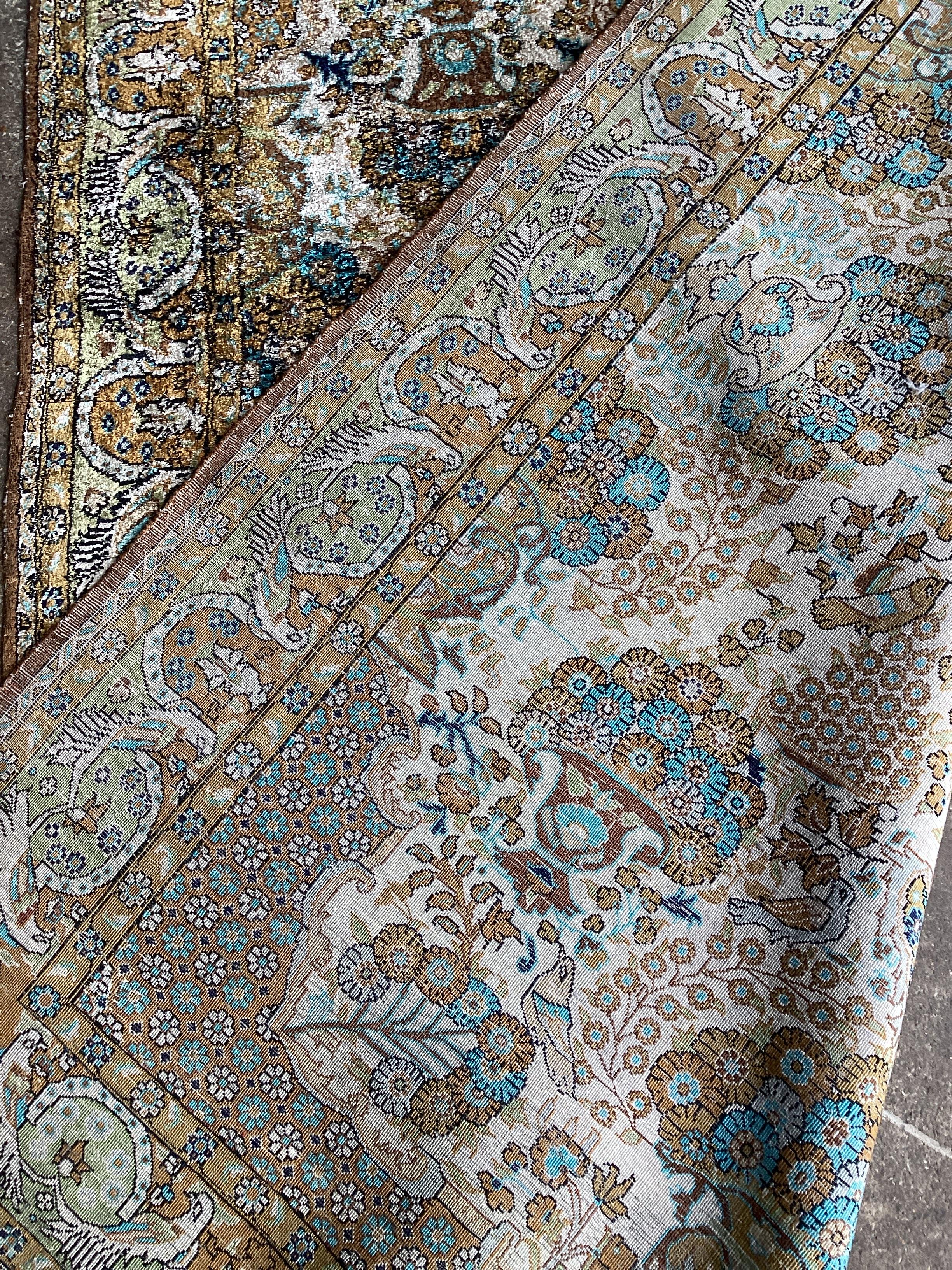 A Tabriz silk rug, woven with floral bouquets about a central medallion, 154 x 111cms